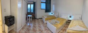 a hotel room with two beds and a television at Luxor View Hotel in Luxor
