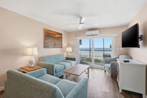 a living room with a couch and chairs and a television at Windward Passage in Fort Myers Beach