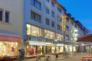 a building on a street with tables and chairs at Hotel Erbprinzenhof in Karlsruhe