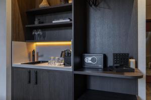 a kitchen with a sink and a microwave in a cabinet at WABI-SABI Hôtel Lorrain - Self Check-in in Nice