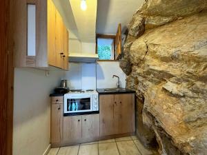 a kitchen with a microwave and a stone wall at Kofinas villa Evdilos by BRP-PROPERTIES in Evdilos +31 photos