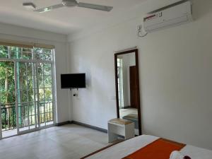 a bedroom with a bed and a mirror and a tv at Hillkandy in Kengalla