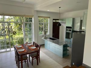 a kitchen with a table and chairs and a kitchen with a refrigerator at Hillkandy in Kengalla