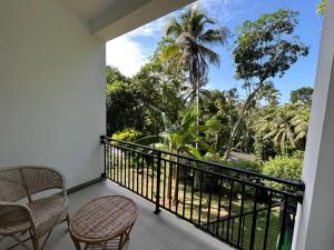 a balcony with chairs and a view of the jungle at Hillkandy in Kengalla