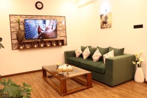 a living room with a green couch and a tv at Ambula Resort in Nuwara Eliya