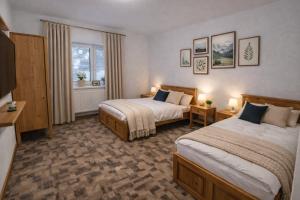 a hotel room with two beds and a television at Hangot Apartments in Repisko