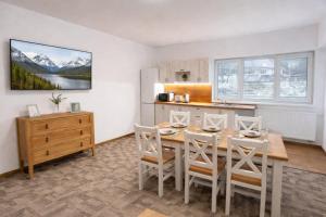 a kitchen and dining room with a table and chairs at Hangot Apartments in Repisko
