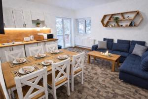a living room with a table and a blue couch at Hangot Apartments in Repisko
