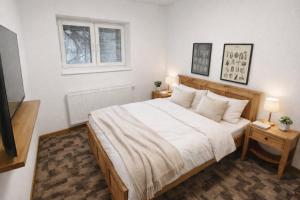 a bedroom with a bed with white sheets and a window at Hangot Apartments in Repisko +6 photos