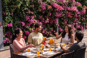 a group of people sitting around a table eating food at SaffronStays Eden - 3BR vineyard-side pool villa with jacuzzi, farm dining, stargazing deck & lawns for celebrations in Nashik +58 photos