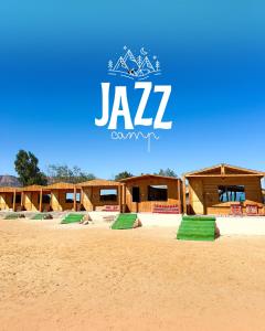 a group of wooden huts on a sandy beach at Jazz Nuwibaa Camp in Wāsiţ