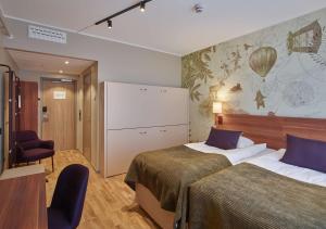 a hotel room with two beds and a white screen at Scandic Luleå in Luleå +26 photos