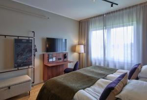 a hotel room with a bed and a flat screen tv at Scandic Luleå in Luleå
