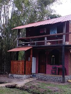 a red brick house with a balcony on top at Bangalo O Galo in Itacaré