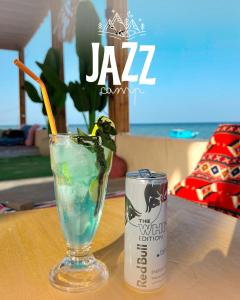 a drink in a glass next to a can on a table at Jazz Nuwibaa Camp in Wāsiţ