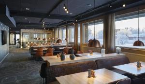 a restaurant with tables and chairs and large windows at Scandic Luleå in Luleå