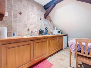 a kitchen with wooden cabinets and a sink at Les Perles du Ried - Gîte 8 - 15mn Europapark - proche Strasbourg Colmar in Boofzheim