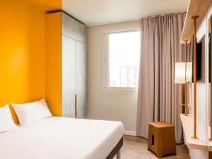 a hotel room with a bed and a window at Ibis Budget Amiens Centre Gare in Amiens