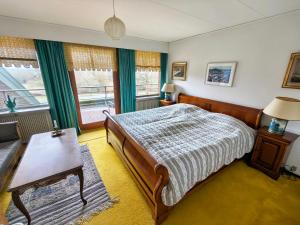 a bedroom with a bed and a table and windows at Sæbygaard Estate Kalundborg in Ruds-Vedby