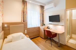 a hotel room with a bed and a desk at Hotel Erbprinzenhof in Karlsruhe