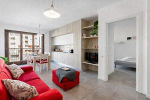 a living room with a red couch and a kitchen at Sarca 11th Floor in Milan