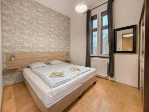 a bedroom with a bed with two hats on it at K13 Gozsdu Apartment in Budapest