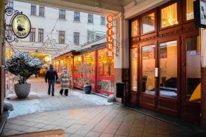a couple of people walking down a street near a store at K13 Gozsdu Apartment in Budapest