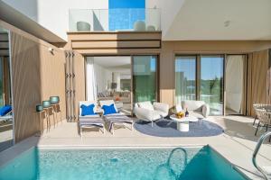 a living room with a swimming pool and a house at Villa Valea - Managed by Excelsior Villas in Turanj