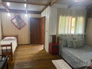 a bedroom with a bed and a window at Pousada Cantuá in Ilha do Mel
