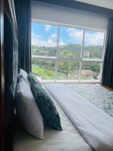 a bed with pillows in front of a large window at Ambula Resort in Nuwara Eliya +73 photos