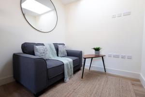 a living room with a blue couch and a mirror at Albert Hall 1 Bed ApartHotel- Food & Bar Onsite in Swansea