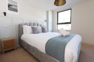 a bedroom with a large white bed with a window at Albert Hall 1 Bed ApartHotel- Food & Bar Onsite in Swansea +14 photos