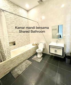 a bathroom with a tub and a toilet and a sink at Ndalem Suryo Guesthouse in Yogyakarta +15 photos