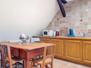 a kitchen with a wooden table and wooden chairs at Les Perles du Ried - Gîte 9 proche Europa-park in Boofzheim