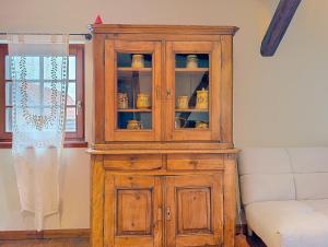 a wooden cabinet with china in a room at Les Perles du Ried - Gîte 9 proche Europa-park in Boofzheim
