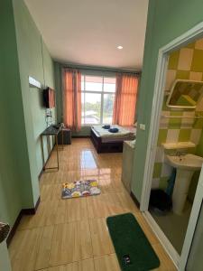 a small room with a bed and a wooden floor at ใบไม้ in Ko Si Chang