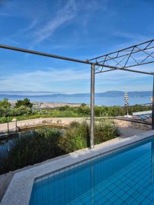 a swimming pool with a view of the desert at Villa Suzi - Family Farm Stay with Donkeys, Pool and Sea View near Rijeka in Šmrika
