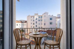 a table with chairs and a coffee cup on a balcony at WABI-SABI Hôtel Lorrain - Self Check-in in Nice +34 photos