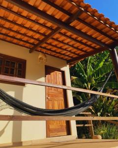a hammock on the porch of a house at Pousada Jardim da Vida in Palmeiras