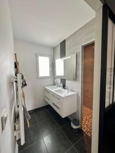 a bathroom with a white sink and a mirror at L Ecrin d Anabelle in Saint-Georges-lès-Baillargeaux