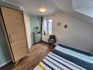 a bedroom with a bed and a window and a chair at # Ausblick LübEck in Lübeck