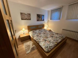 a bedroom with a bed and two lamps on tables at Borealis Apartment in Bansko