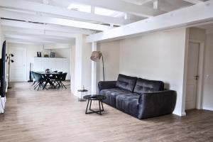 a living room with a black couch and a table at Hotel Colonnaden by O&N in Hamburg
