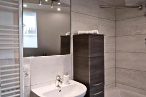 a bathroom with a sink and a mirror and a tub at Hotel Colonnaden by O&N in Hamburg +8 photos