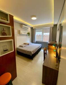 a bedroom with a bed and a table in it at Garden Moinhos de Vento in Porto Alegre