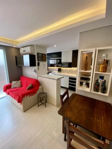 a living room with a red couch and a kitchen at Garden Moinhos de Vento in Porto Alegre