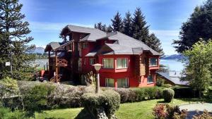 a large red house on top of a yard at Solar de las Araucarias in San Carlos de Bariloche