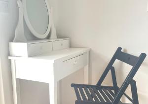 a black chair next to a white dresser with a mirror at Apartment mit Balkon & Bergblick inklusive Parkplatz in Christofberg