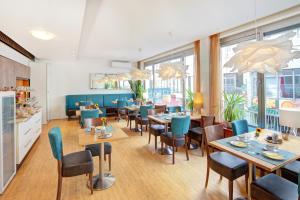 a restaurant with tables and chairs and windows at Hotel Erbprinzenhof in Karlsruhe