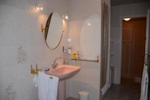 a white bathroom with a sink and a mirror at Demeure de la pompe in La Queue-en-Brie
